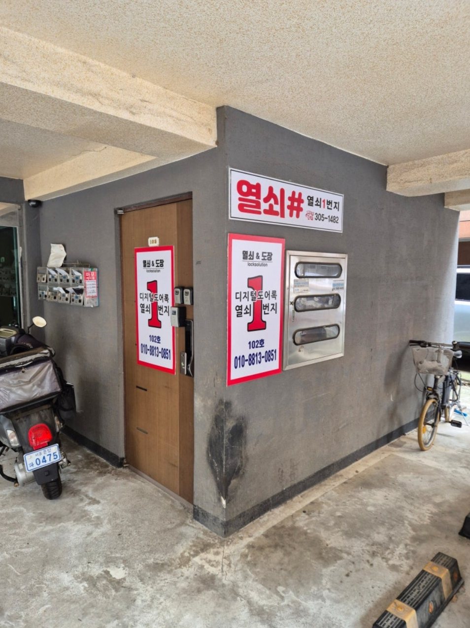 합정아르빌 필로티 안쪽, 열쇠1번지 간판이 붙은 102호 출입문